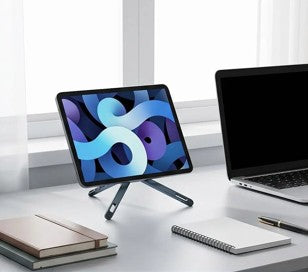 Support pliable pour tablette avec tablette posée sur un bureau blanc, près d’un ordinateur portable et de fournitures de bureau