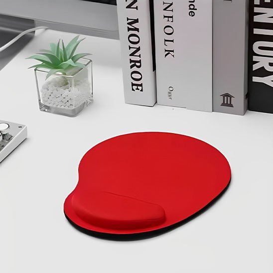 Tapis de souris repose poignée Tapis de souris ergonomique rouge avec repose-poignet, posé sur un bureau blanc près de livres et d’une petite plante