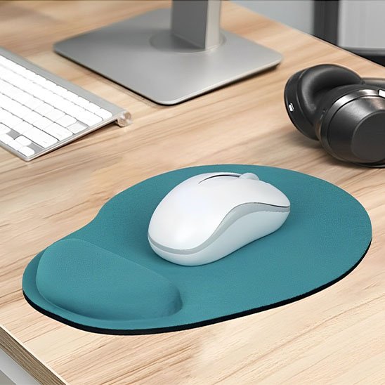 Tapis de souris repose poignéeSouris blanche posée sur un tapis de souris ergonomique bleu avec repose-poignet, sur un bureau avec clavier et casque